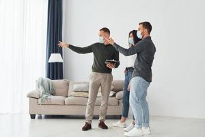 Man helps the young couple in choosing an apartment photo