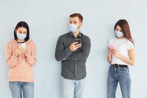 tres personas de pie juntas en el estudio con fondo blanco foto