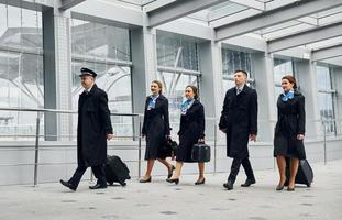 Airplane crew in uniform is going to the work together photo