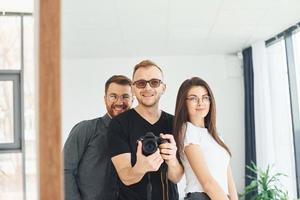 Man with camera doing photo in the mirror of himself and his friends