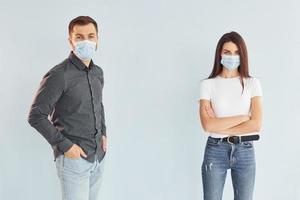 Man and woman standing indoors in the studio against white background photo
