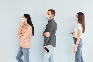 Three people standing together in the studio against white background photo