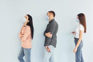 Three people standing together in the studio against white background photo