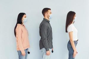 tres personas de pie juntas en el estudio con fondo blanco foto