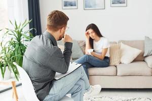 Young woman at a reception at a psychologist. Sits on the sofa photo