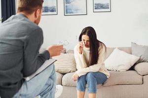 mujer joven en una recepción en un psicólogo. llorando y hablando de problemas foto