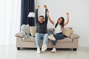 Happy owners of a new apartment is sitting on the sofa photo