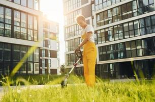 Beautiful sunshine. Man cut the grass with lawn mover outdoors in the yard photo