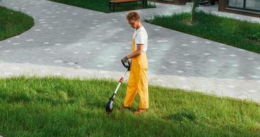 Distant view. Man cut the grass with lawn mover outdoors in the yard photo