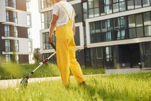 Busy day. Man cut the grass with lawn mover outdoors in the yard photo