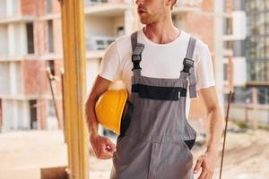 Big project. Young man working in uniform at construction at daytime photo