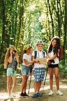 Weekend activies. Kids strolling in the forest with travel equipment photo