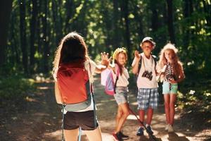 listo para la aventura. niños paseando por el bosque con equipo de viaje foto