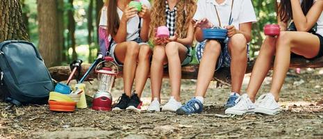 Taking a break. Kids strolling in the forest with travel equipment photo