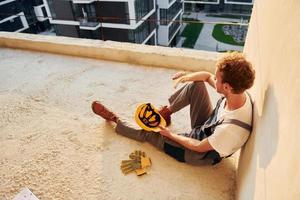 joven que trabaja en uniforme en la construcción durante el día foto