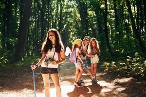 listo para la aventura. niños paseando por el bosque con equipo de viaje foto