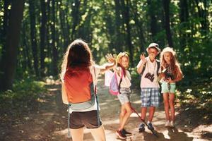 listo para la aventura. niños paseando por el bosque con equipo de viaje foto