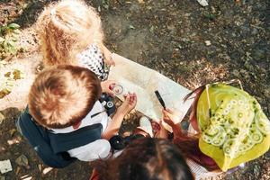 Top view. Kids strolling in the forest with travel equipment photo