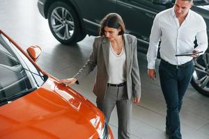 View from above. Man in formal wear helping customer with choice of the automobile photo