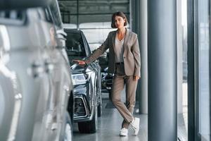 tecnología moderna. la mujer está adentro cerca de un automóvil nuevo adentro foto