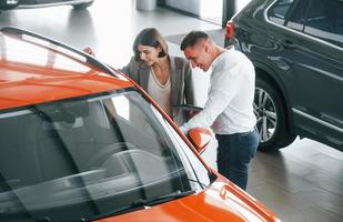 View from above. Man in formal wear helping customer with choice of the automobile photo