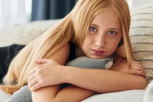 retrato de una adolescente con cabello rubio que está en casa durante el día foto