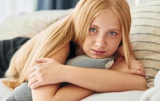 retrato de una adolescente con cabello rubio que está en casa durante el día foto