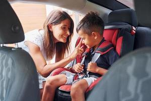 Woman with little boy is in the modern automobile at daytime photo