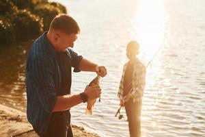 con captura padre e hijo pescando juntos al aire libre en verano foto