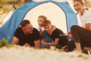 Conception of vacation. Family of mother, father and kids is on the camping photo