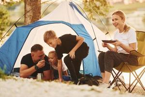 Active time spending. Family of mother, father and kids is on the camping photo