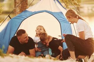 Conception of vacation. Family of mother, father and kids is on the camping photo