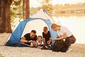 Conception of vacation. Family of mother, father and kids is on the camping photo