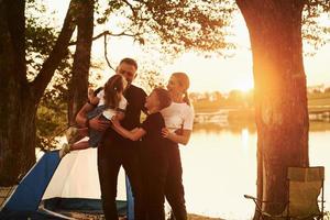 Active time spending. Family of mother, father and kids is on the camping photo