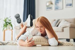 Front view. Female teenager with blonde hair is at home at daytime photo