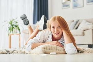 Front view. Female teenager with blonde hair is at home at daytime photo