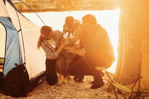 hermosa luz del sol. la familia de madre, padre e hijos está acampando foto