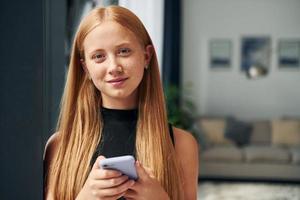 una adolescente con cabello rubio está en casa durante el día foto