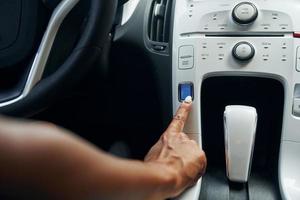 Close up view of front control panel. Woman in casual clothes is sitting in her automobile at daytime photo