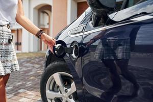 Woman is outdoors with her modern automobile photo