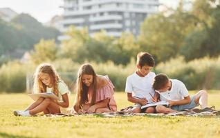 Conception of hobbies. Group of happy kids is outdoors on the sportive field at daytime photo