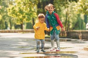 Kids having fun outdoors in the park after the rain photo