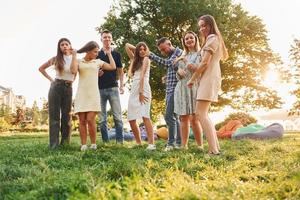 actividades de fin de semana. grupo de jóvenes tienen una fiesta en el parque durante el día de verano foto