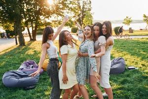 Women's party. Group of young people have fun in the park at summer daytime photo