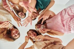 vista desde abajo. grupo de mujeres felices que está en una despedida de soltera foto