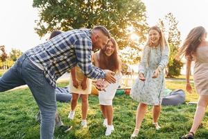 actividades de fin de semana. grupo de jóvenes tienen una fiesta en el parque durante el día de verano foto