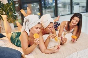 With slices of oranges. Group of happy women that is at a bachelorette party photo