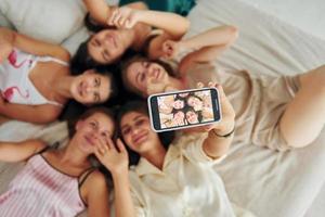 tomando autofoto. vista superior del grupo de mujeres felices que está en una despedida de soltera foto