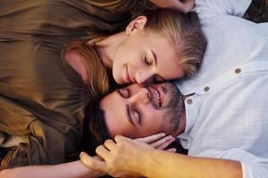 una pareja feliz está al aire libre tumbada en el suelo foto