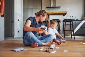 Weekend rest. Father and son is indoors at home together photo